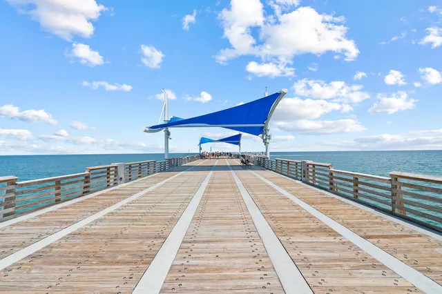 a view of a swimming pool and deck with lawn chairs