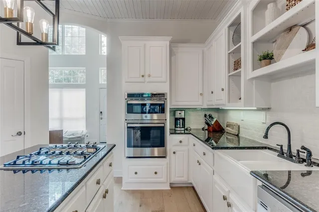 a kitchen with white cabinets and appliances