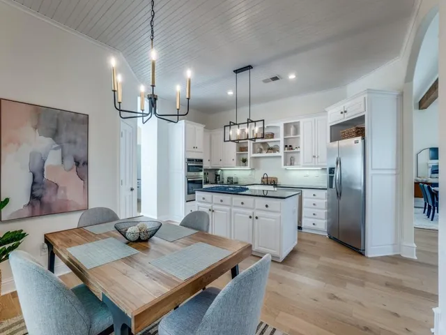 a kitchen with stainless steel appliances granite countertop a kitchen island and a refrigerator