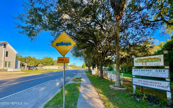 a sign board with a yard and plants