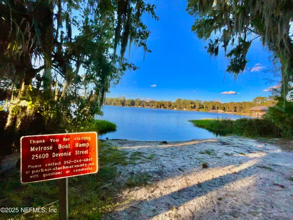 a sign board with a house in the background
