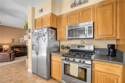 a kitchen with stainless steel appliances granite countertop a stove a refrigerator and a cabinets