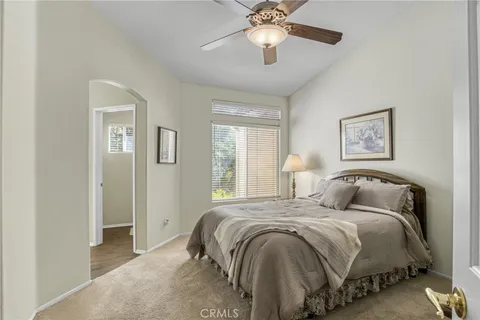 a bedroom with a large bed and a chandelier