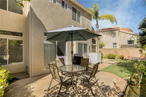 a patio with a table and chairs under an umbrella