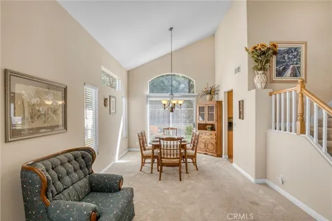a living room with furniture a dining table and a chandelier