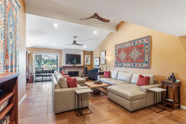 a living room with furniture a flat screen tv and a fireplace