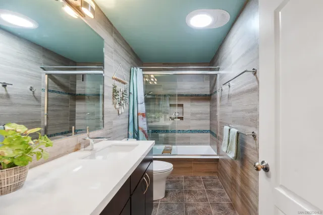 a bathroom with a granite countertop sink a toilet and shower