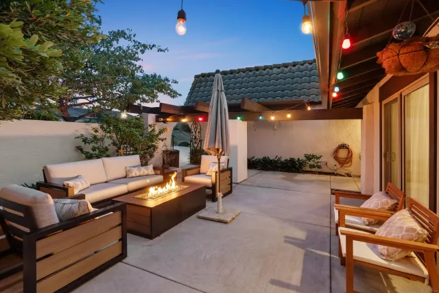 a view of a patio with couches table and chairs and potted plants