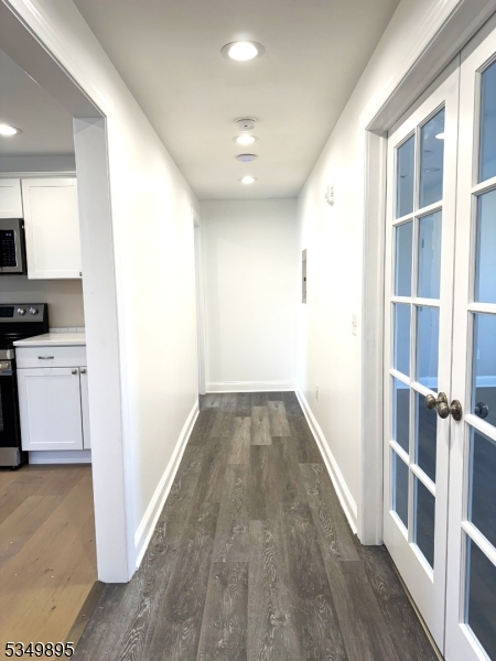 a view of a hallway with wooden floor and staircase