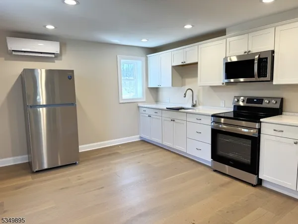 a kitchen with stainless steel appliances granite countertop a refrigerator stove a sink and a microwave