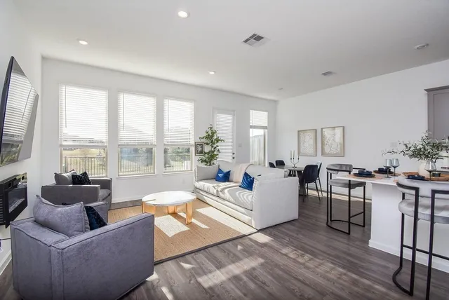 a living room with furniture and floor to ceiling windows