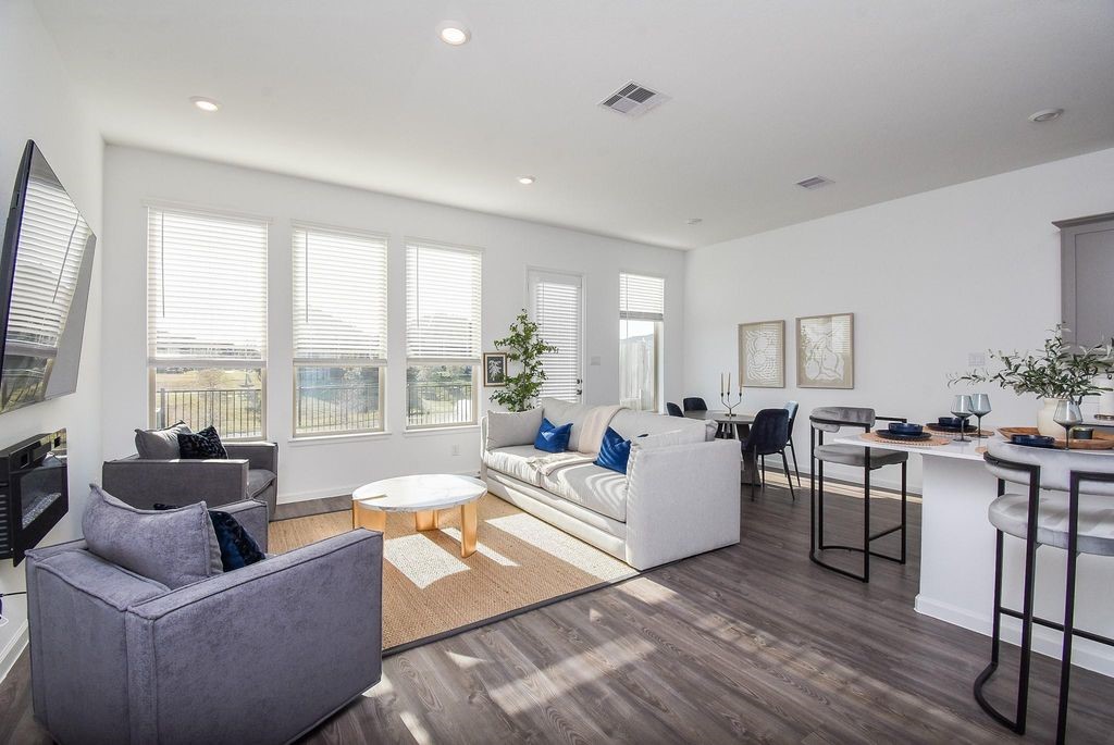 a living room with furniture and floor to ceiling windows