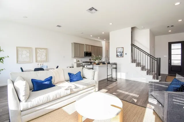 a living room with furniture and a view of kitchen