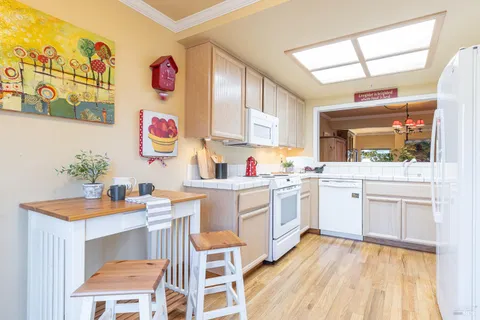 a kitchen with a sink cabinets and wooden floor
