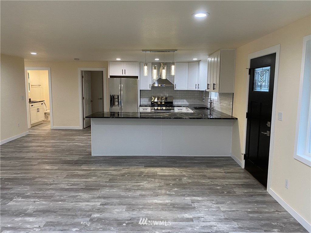 17326 North Road Bothell, WA 98012 - Photo 3 of 27 a kitchen with stainless steel appliances granite countertop a sink and a refrigerator