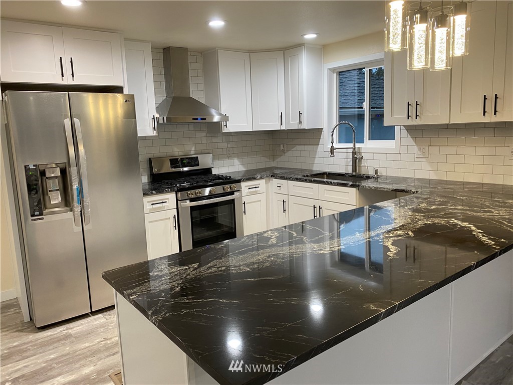 17326 North Road Bothell, WA 98012 - Photo 4 of 27 a kitchen with stainless steel appliances granite countertop a sink a stove and a refrigerator