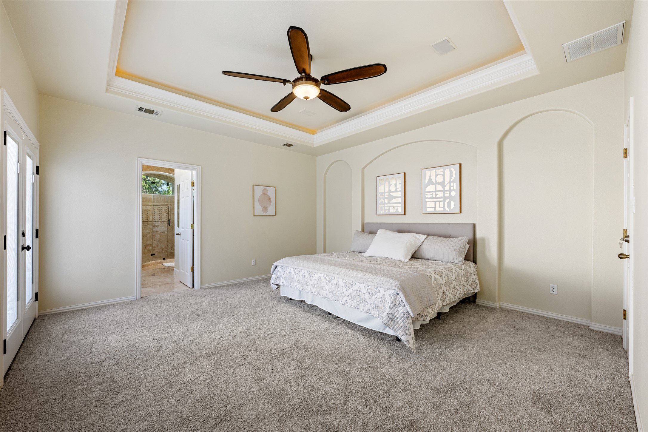 181 Whitney Run Buda, TX 78610 - Photo 20 of 40 Fabulous primary bedroom with tray ceiling and tons of natural light. There is a large walk-in closet in both the primary bedroom & primary bath.