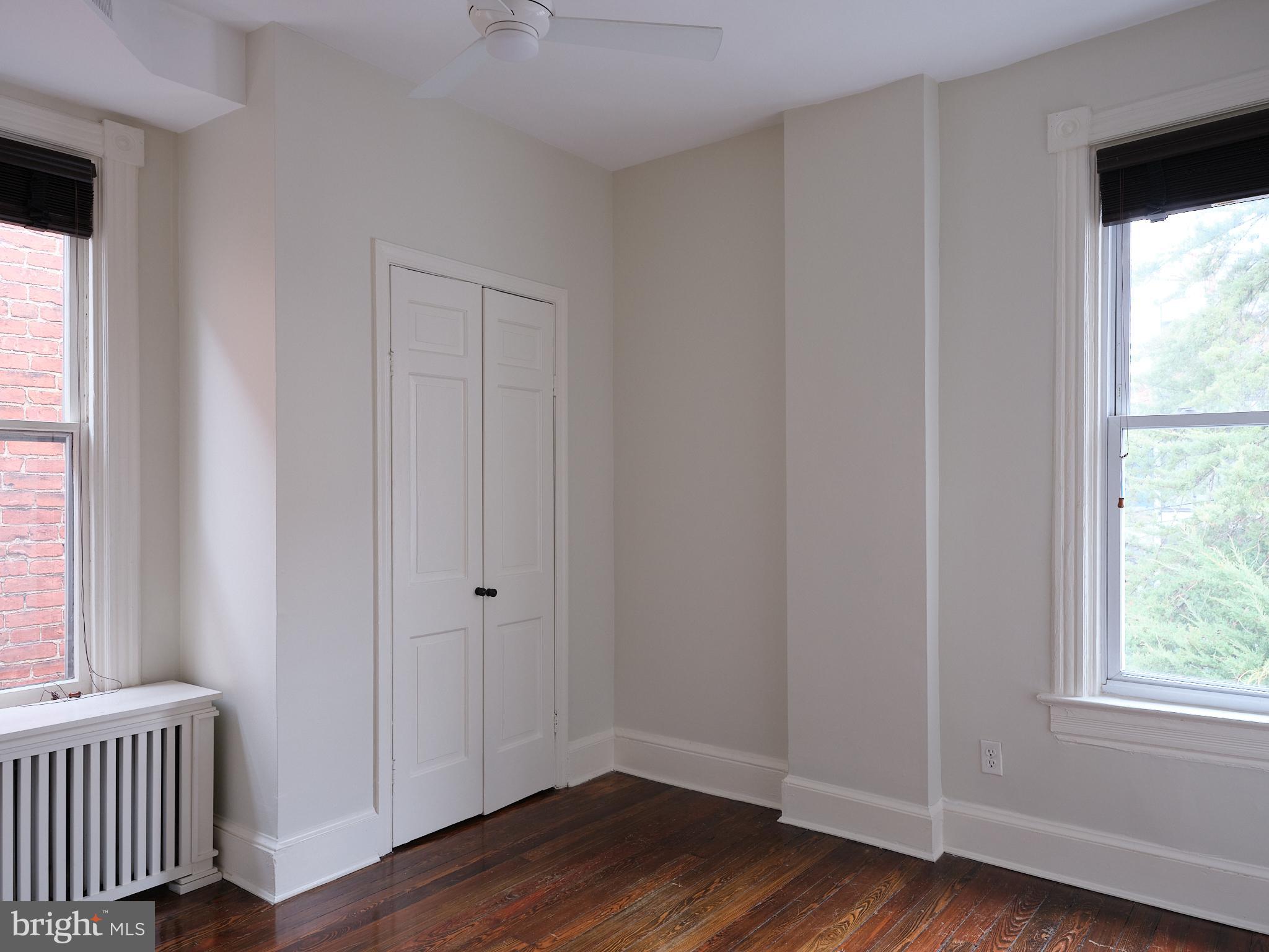 1624 Swann Street Northwest Washington, DC 20009 - Photo 13 of 16 an empty room with wooden floor and windows