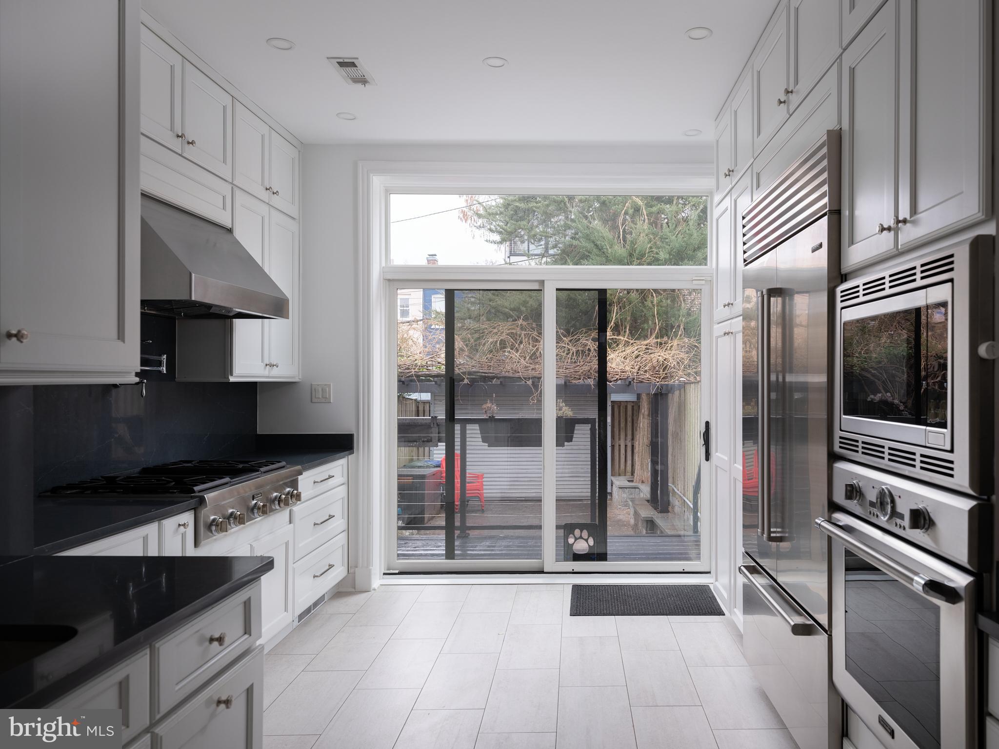 1624 Swann Street Northwest Washington, DC 20009 - Photo 4 of 16 a kitchen with stainless steel appliances a sink stove and cabinets