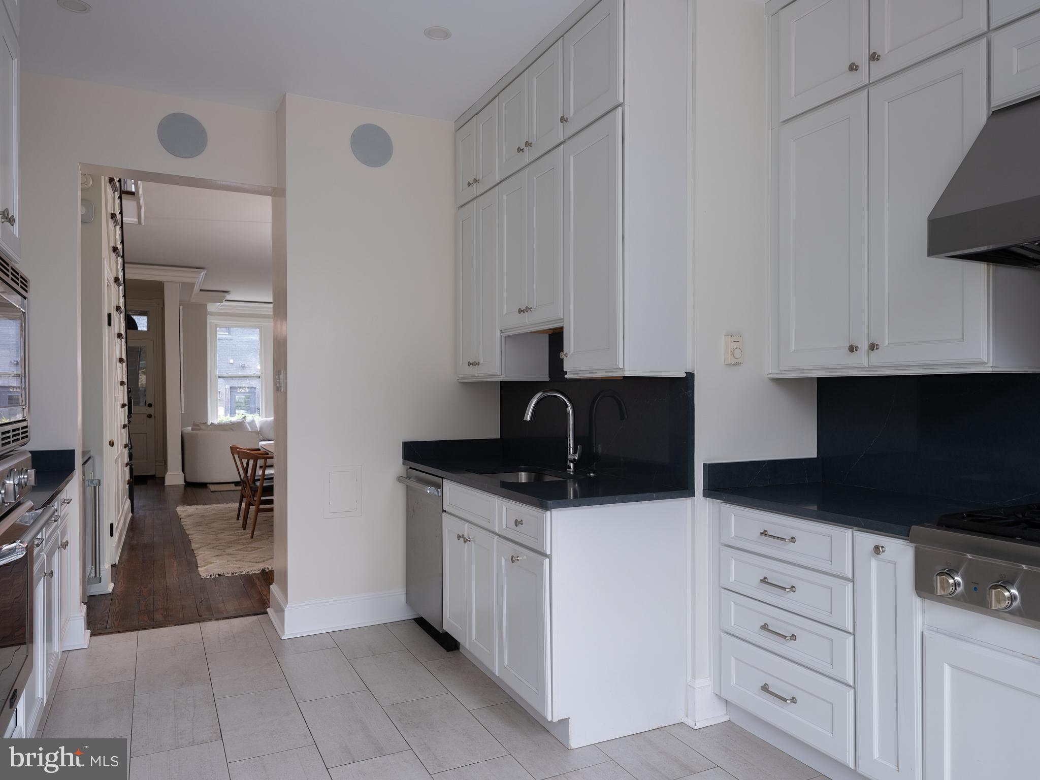 1624 Swann Street Northwest Washington, DC 20009 - Photo 5 of 16 a kitchen with granite countertop a sink a stove and cabinets