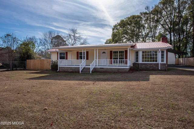 a front view of house with yard and trees around