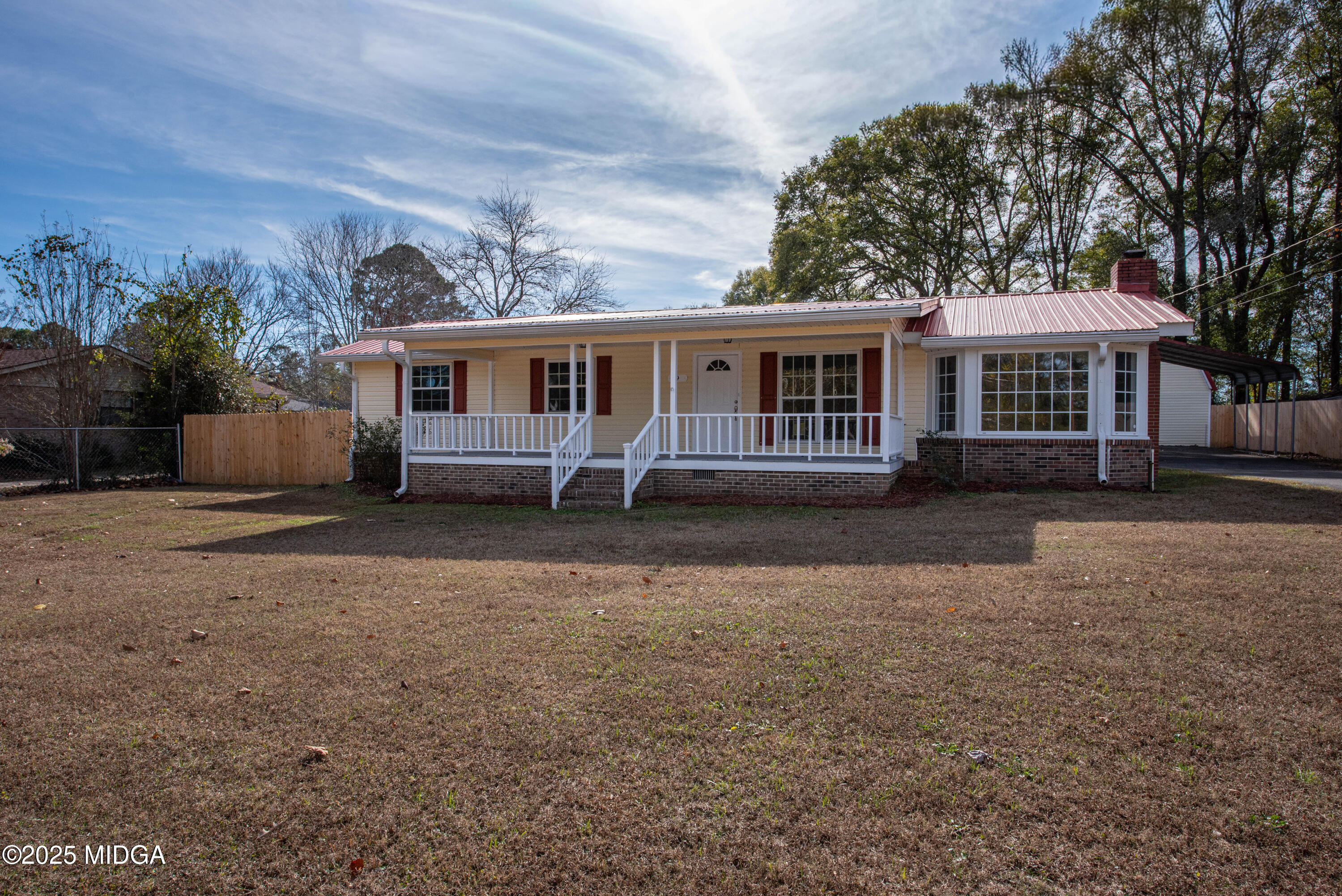 a front view of house with yard and trees around