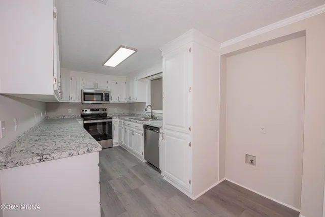 a kitchen with stainless steel appliances granite countertop a stove a sink and a refrigerator