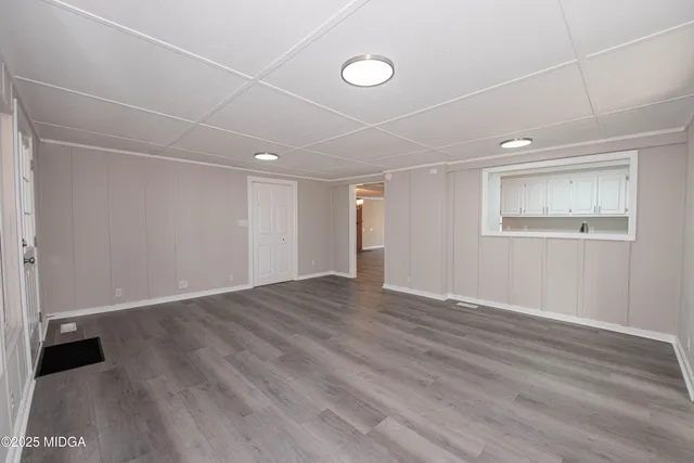 a view of an empty room with wooden floor