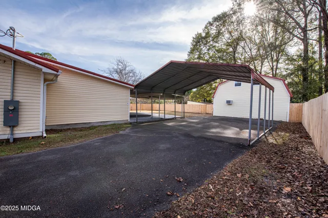 a view of backyard with a barn and large trees