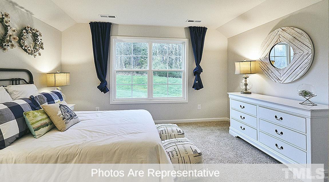 3635 Alcorn Ridge Trace Whitsett, NC 27377 - Photo 2 of 17 a bedroom with a bed and a mirror on dresser