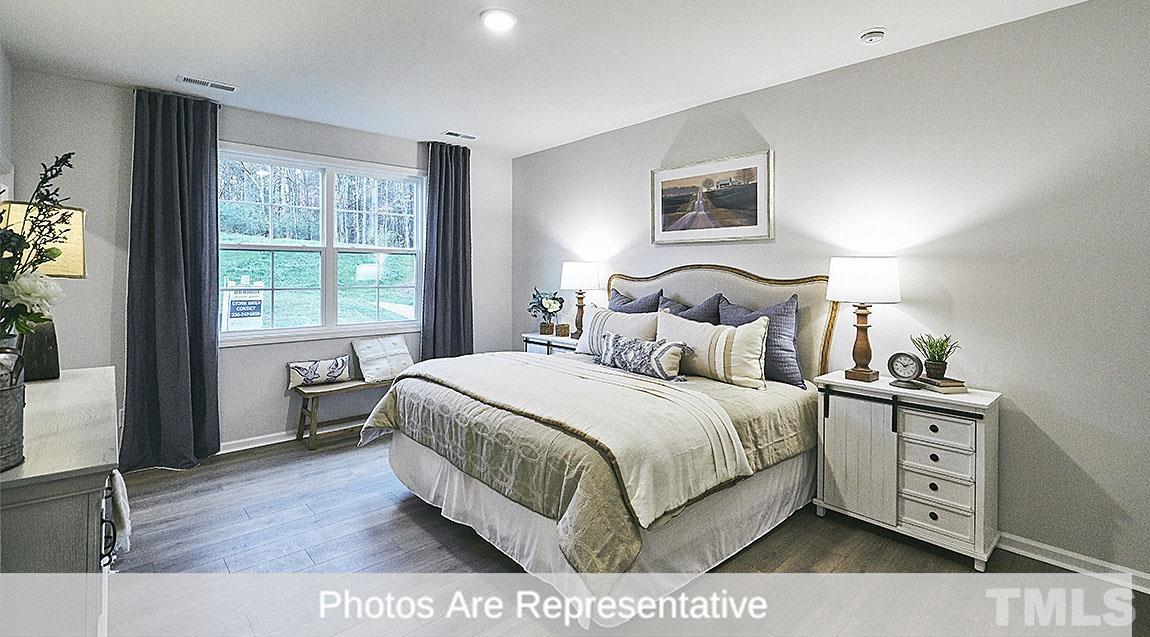 3635 Alcorn Ridge Trace Whitsett, NC 27377 - Photo 12 of 17 a large bedroom with a bed and wooden floor