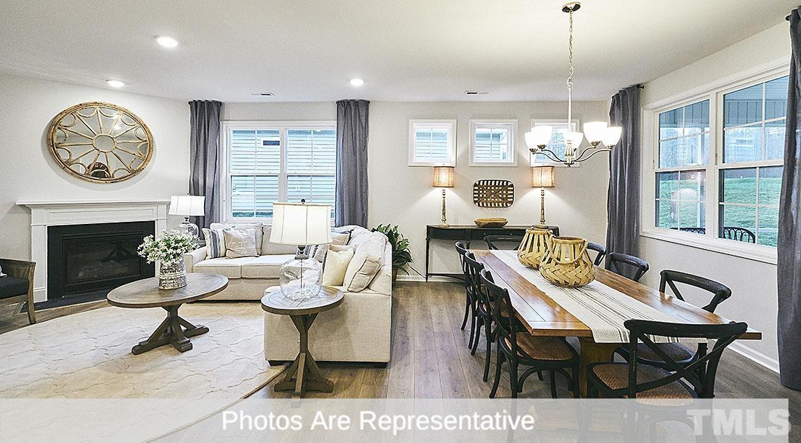 3635 Alcorn Ridge Trace Whitsett, NC 27377 - Photo 15 of 17 a living room with furniture a fireplace and a large window