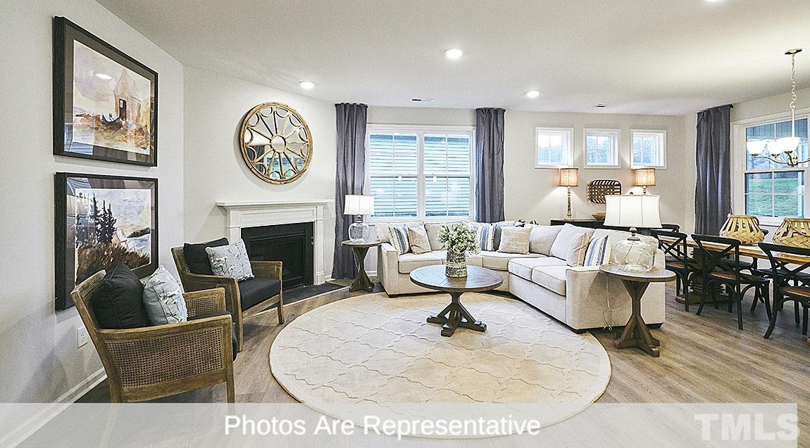 3635 Alcorn Ridge Trace Whitsett, NC 27377 - Photo 17 of 17 a living room with furniture a fireplace and a large window