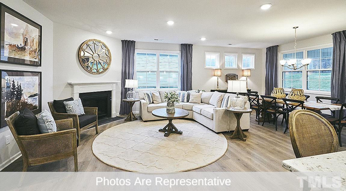 3635 Alcorn Ridge Trace Whitsett, NC 27377 - Photo 5 of 17 a living room with furniture a clock and a fireplace