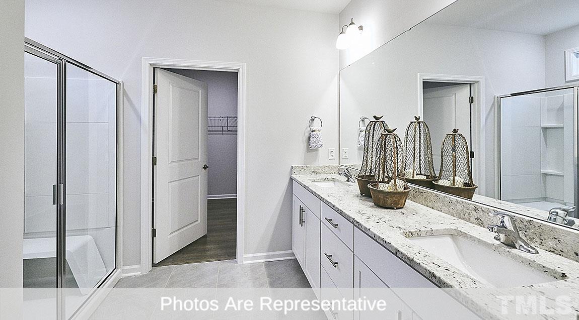3635 Alcorn Ridge Trace Whitsett, NC 27377 - Photo 10 of 17 a bathroom with a granite countertop double vanity sink mirror and shower