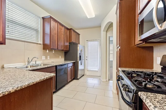 a kitchen with a stove sink and cabinets