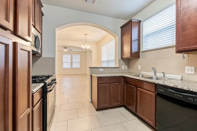 a kitchen with stainless steel appliances granite countertop a sink stove and cabinets