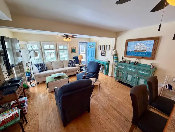a living room with furniture a flat screen tv and wooden floor