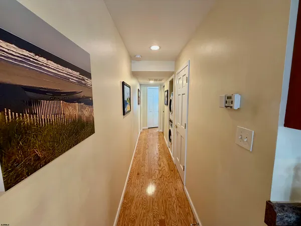 a view of a hallway with wooden floor and staircase