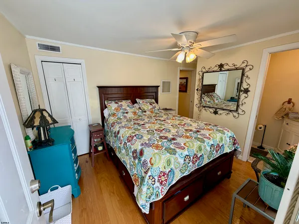 a bedroom with a bed and a mirror on the dresser