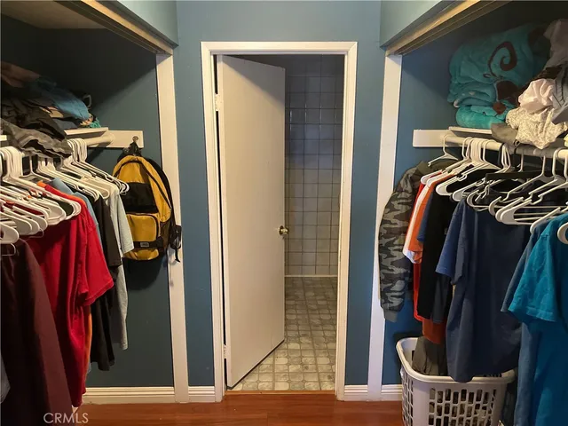 a view of walk in closet with clothes and shoes