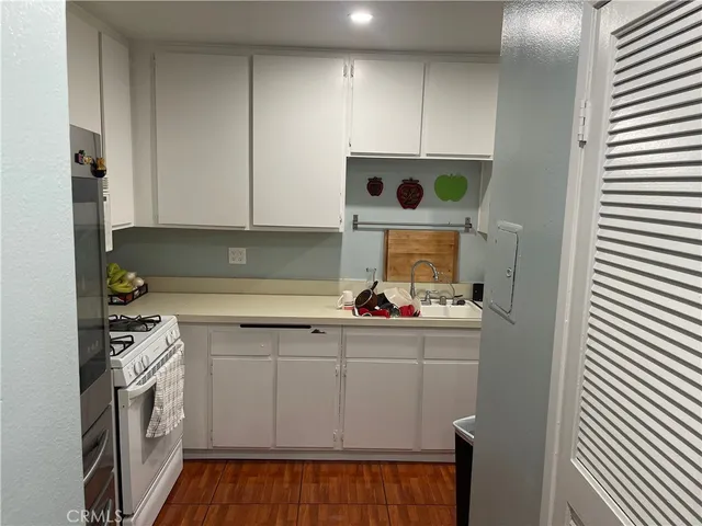 a kitchen with a sink a stove and cabinets
