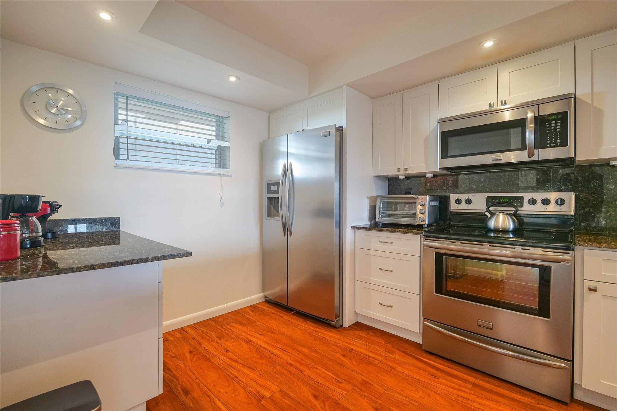 3930 Inverrary Boulevard, Unit 703D Lauderhill, FL 33319 - Photo 14 of 72 a kitchen with stainless steel appliances granite countertop a stove a sink and a refrigerator
