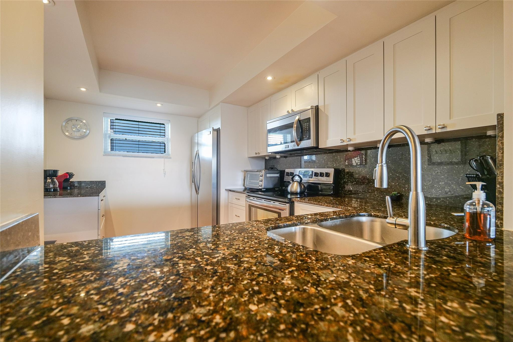 3930 Inverrary Boulevard, Unit 703D Lauderhill, FL 33319 - Photo 20 of 72 a kitchen with stainless steel appliances granite countertop a refrigerator and a stove top oven