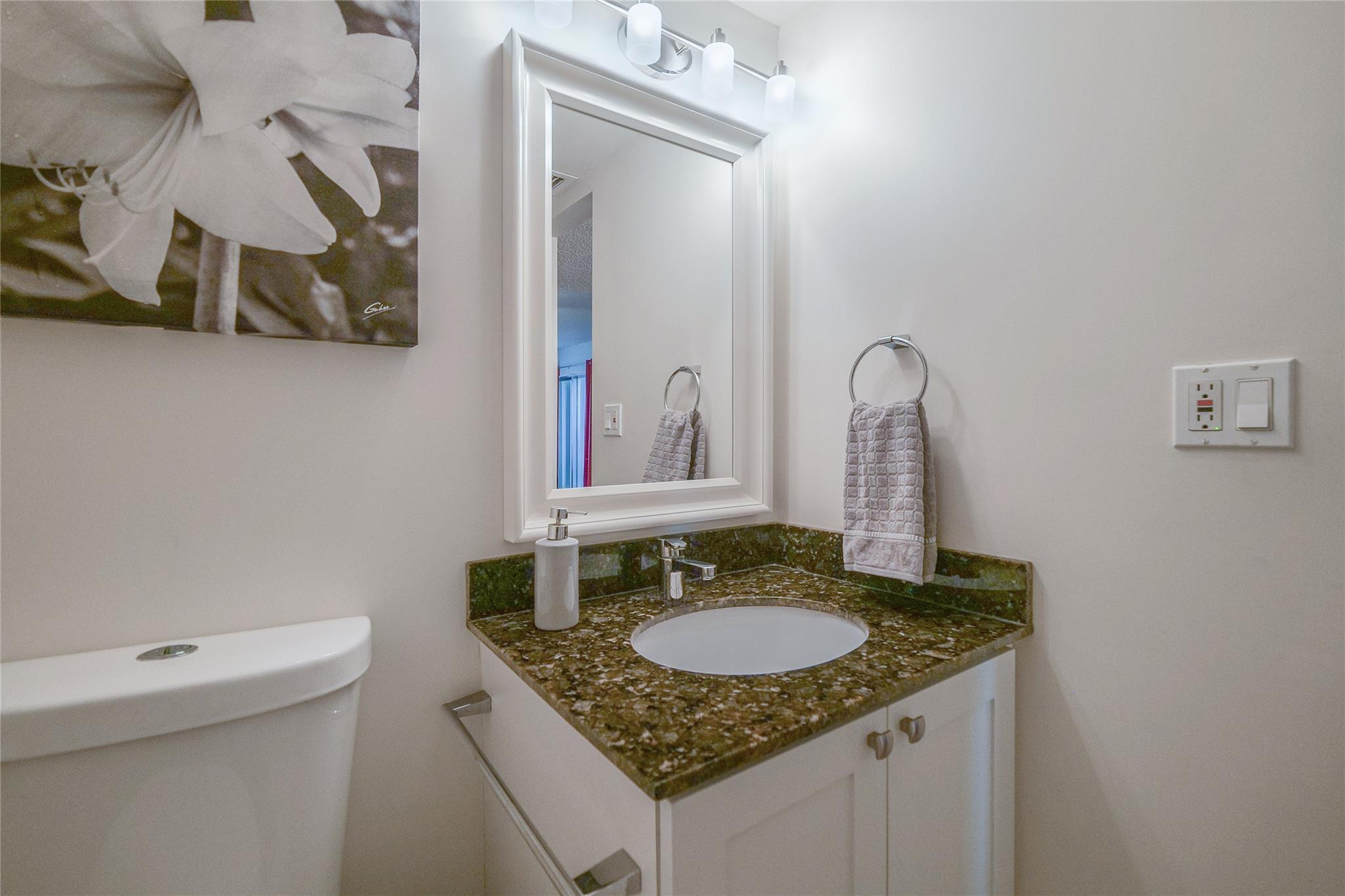 3930 Inverrary Boulevard, Unit 703D Lauderhill, FL 33319 - Photo 32 of 72 a bathroom with a granite countertop sink and a mirror