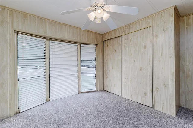 a view of a room with an entryway and a ceiling fan