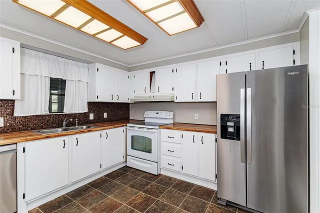 a kitchen with granite countertop a white cabinets and white appliances