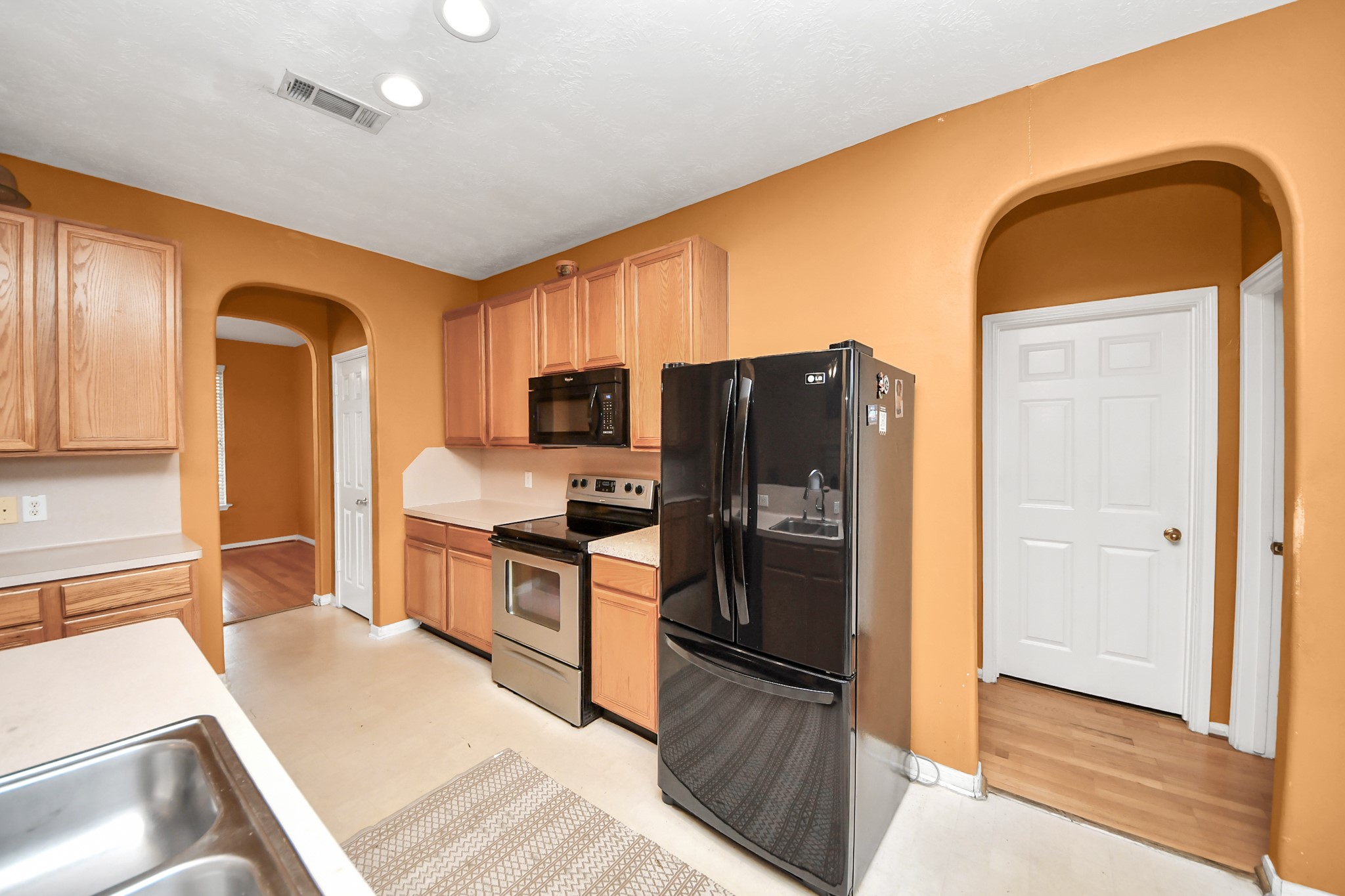 23814 Spring Dane Drive Spring, TX 77373 - Photo 19 of 41 a kitchen with stainless steel appliances granite countertop a refrigerator a stove and a sink with wooden floor