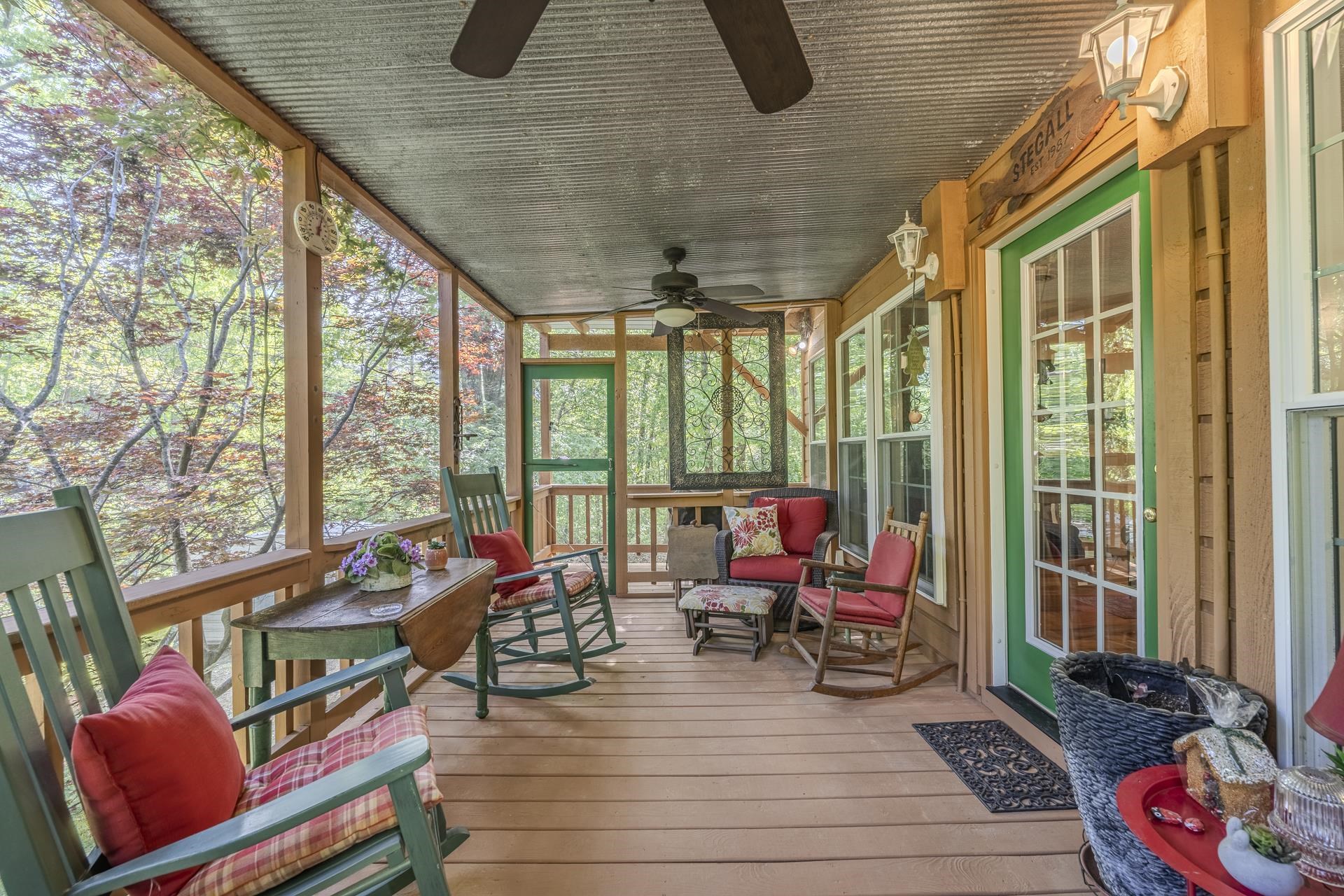 85 Cr 256 Road Iuka, MS 38852 - Photo 15 of 38 Screened porch featuring a corrugated metal ceiling, wood-finish flooring, and multiple ceiling fans