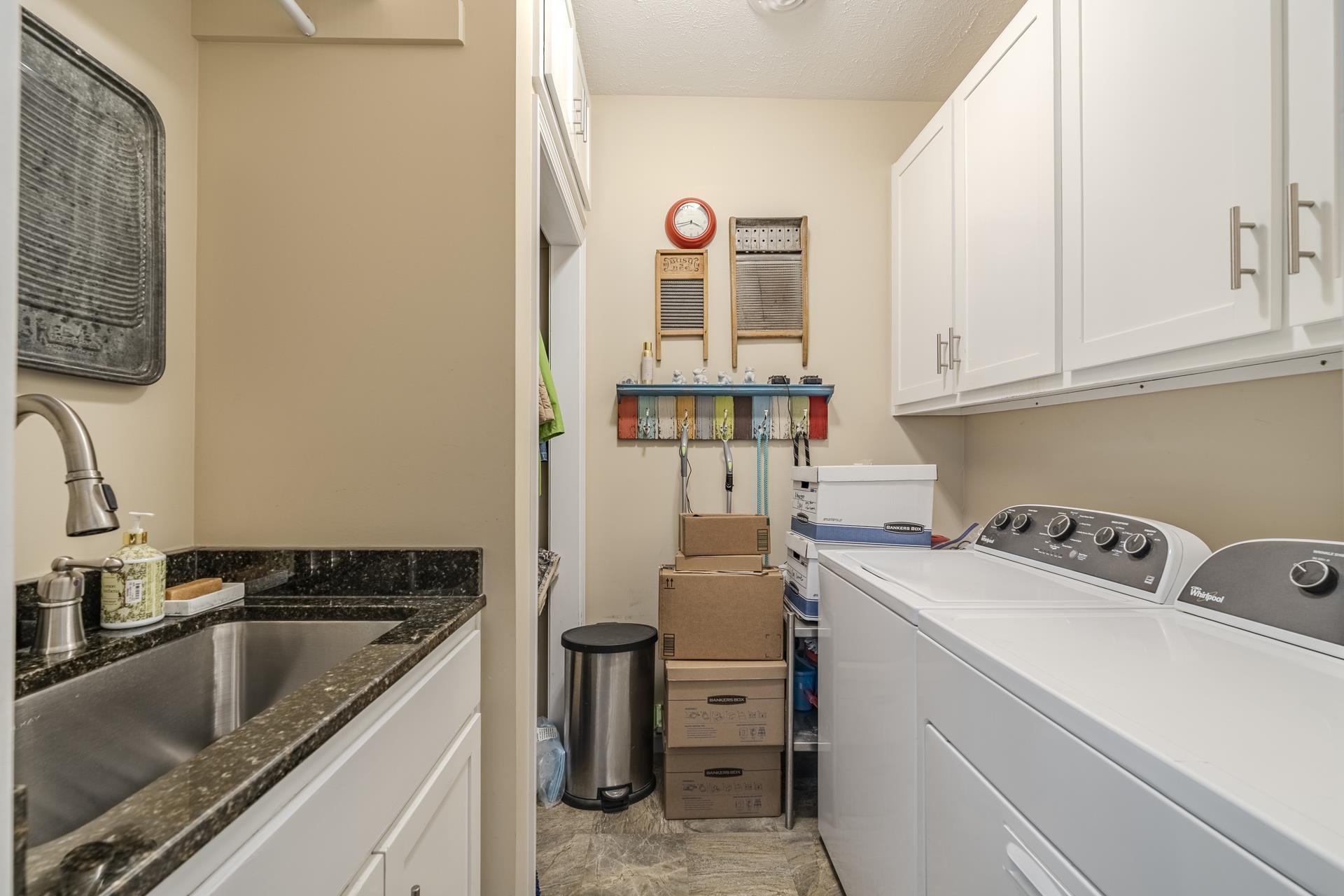 85 Cr 256 Road Iuka, MS 38852 - Photo 16 of 38 Dedicated utility room featuring white cabinetry, a stainless steel sink with a dark speckled countertop, and durable flooring